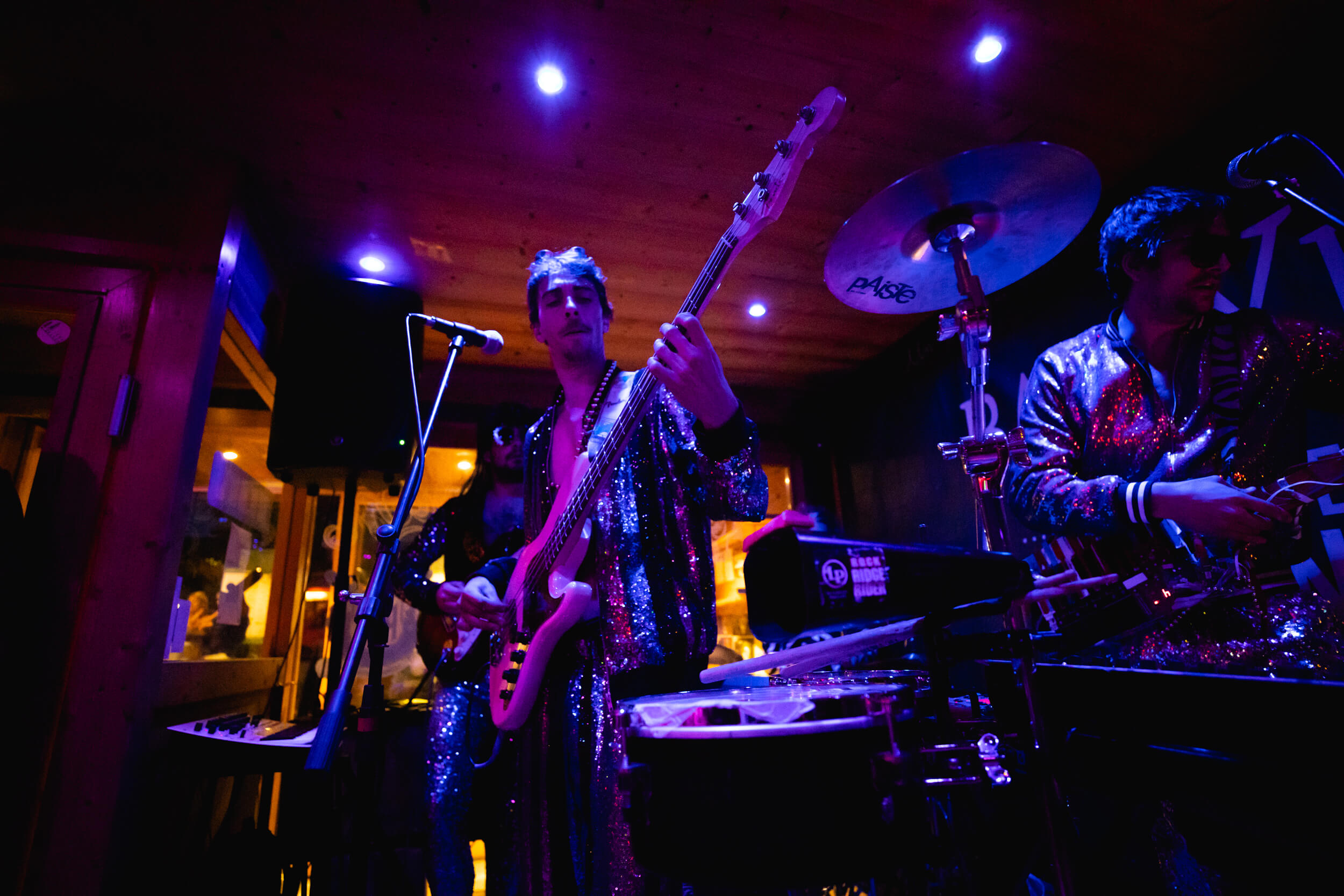 Concert en soirée avec batterie, guitares et chanteur