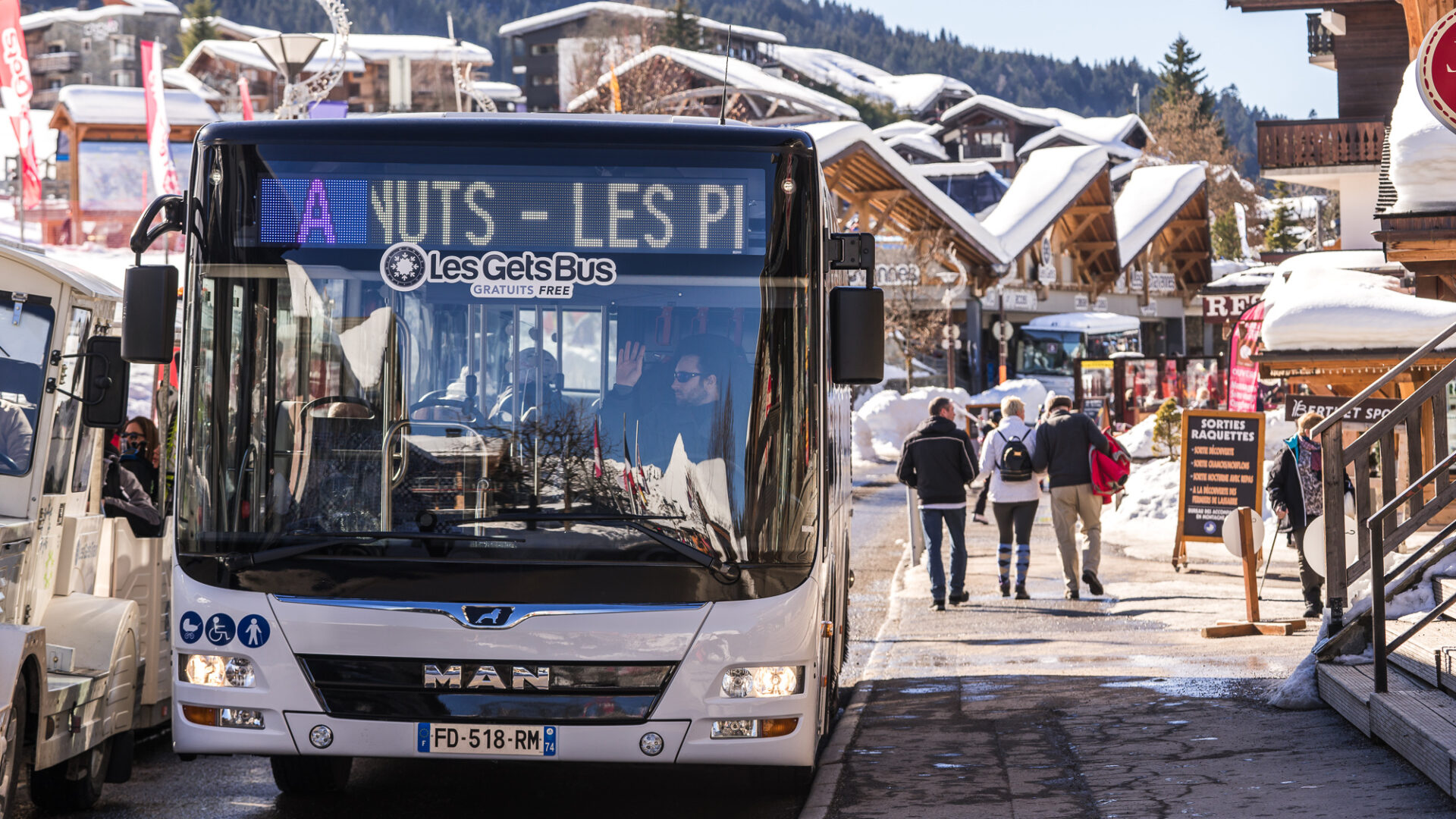 Bus gratuit des Gets en hiver avec village enneigé en fond