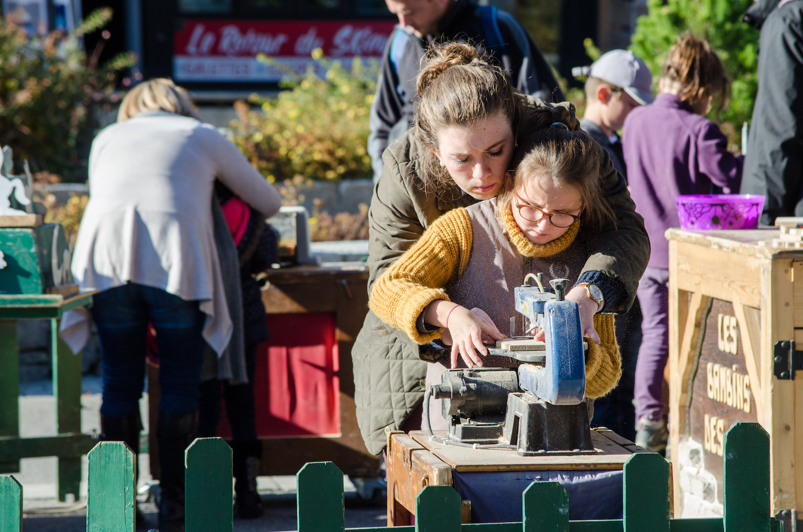 Mom and kid creating a wooden piece during a workshop