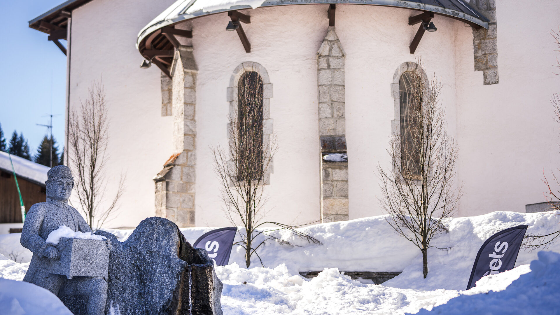 église en hiver avec statue musicien en premier plan