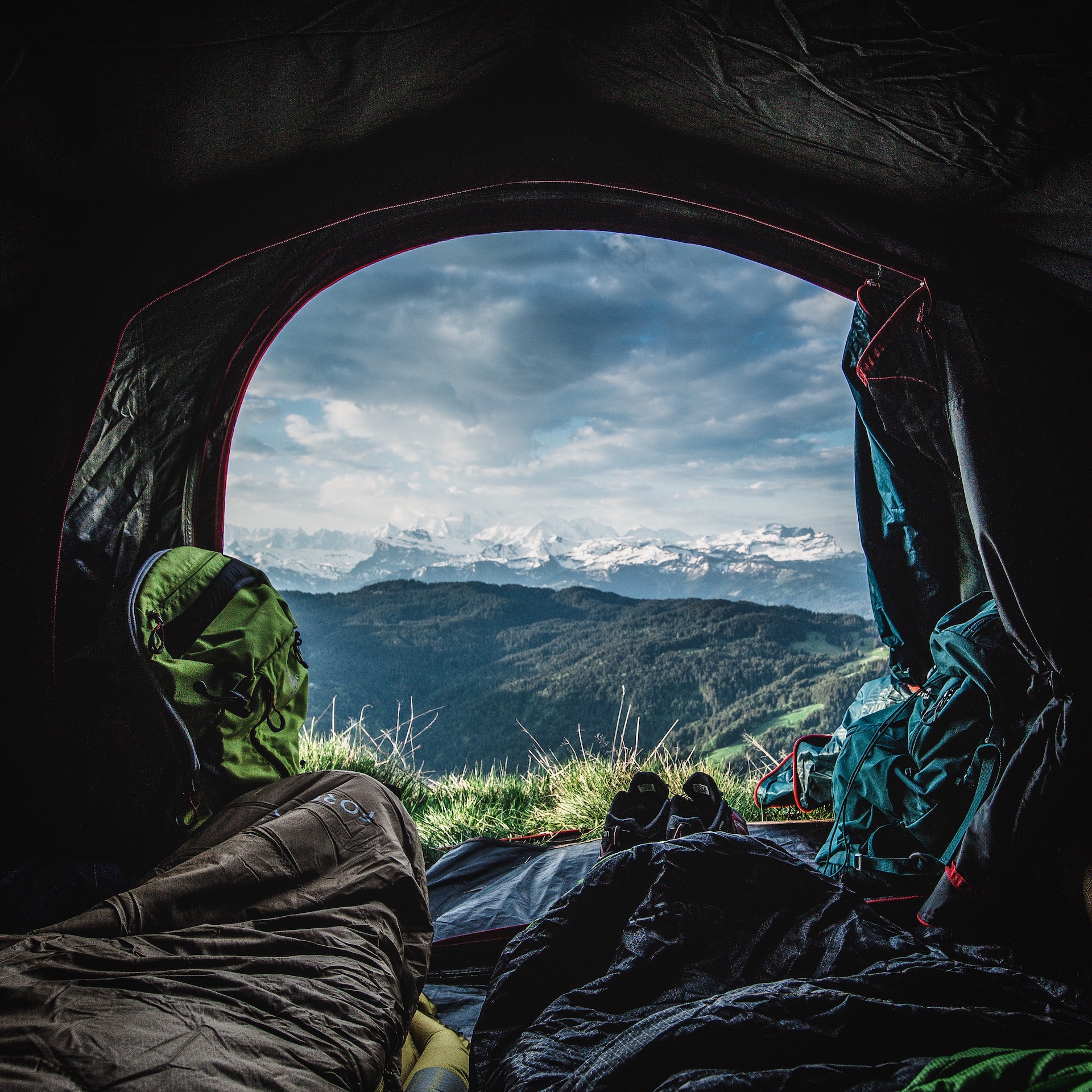 Entrée d'une tente au réveil d'un bivouac en été avec paysage montagne