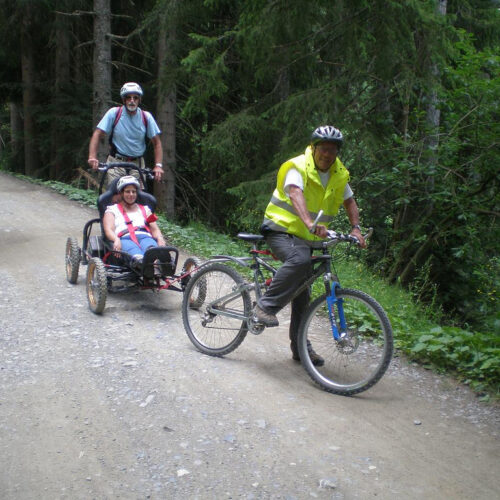 Three people riding MTBs, two of whom are Handi MTBs