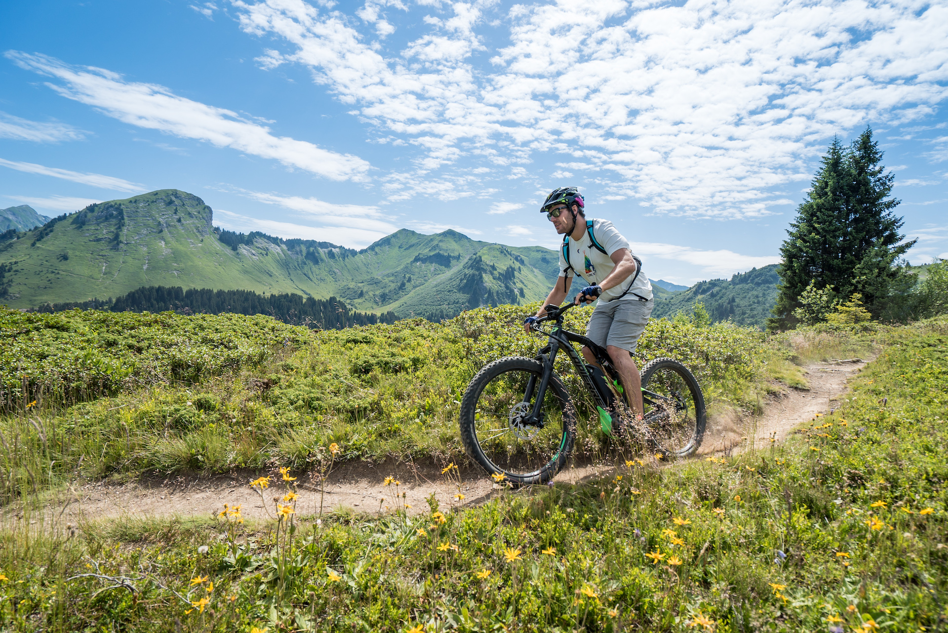 Homme faisant du VTT électrique sur un sentier de montagne en été