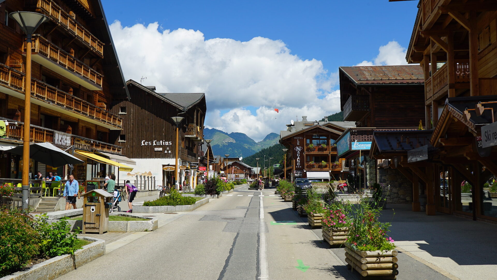 Rue dans le centre d'un village de montagne en été avec montagne en fond