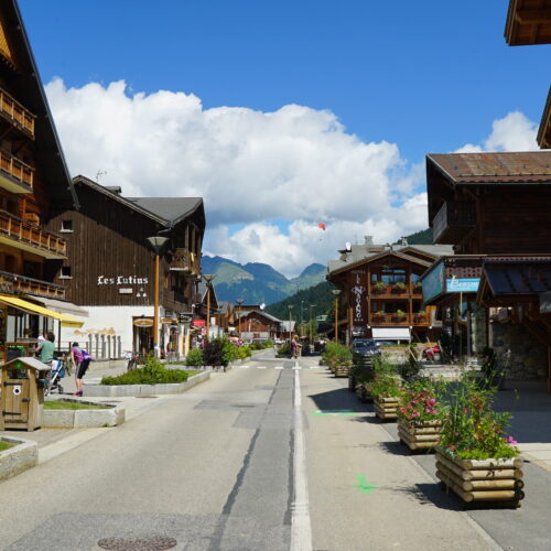 Rue dans le centre d'un village de montagne en été avec montagne en fond