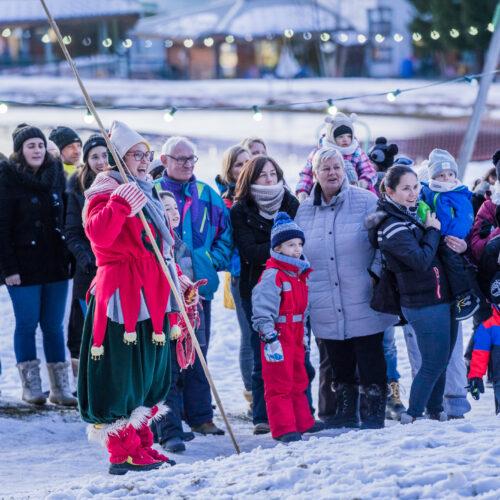 Lutin avec un groupe de personnes à coté un lac en regardent d'une spectacle