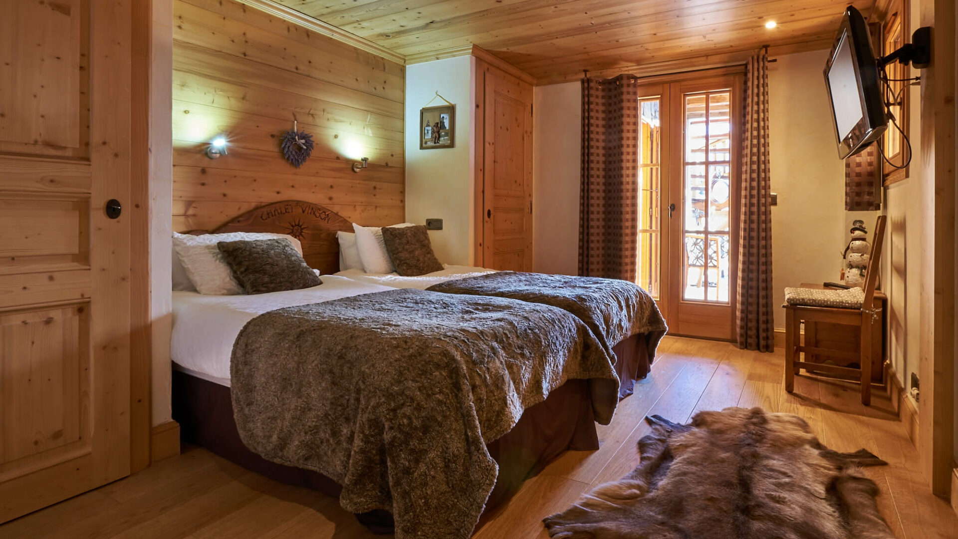 Chambre d'hôtel avec deux lits simples, tout en bois et peau de bête