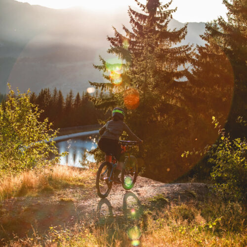 Deme descendant une pite en VTT avec lac et coucher de soleil