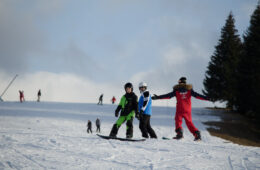 Vacanciers prenant un cours de snowboard avec un moniteur