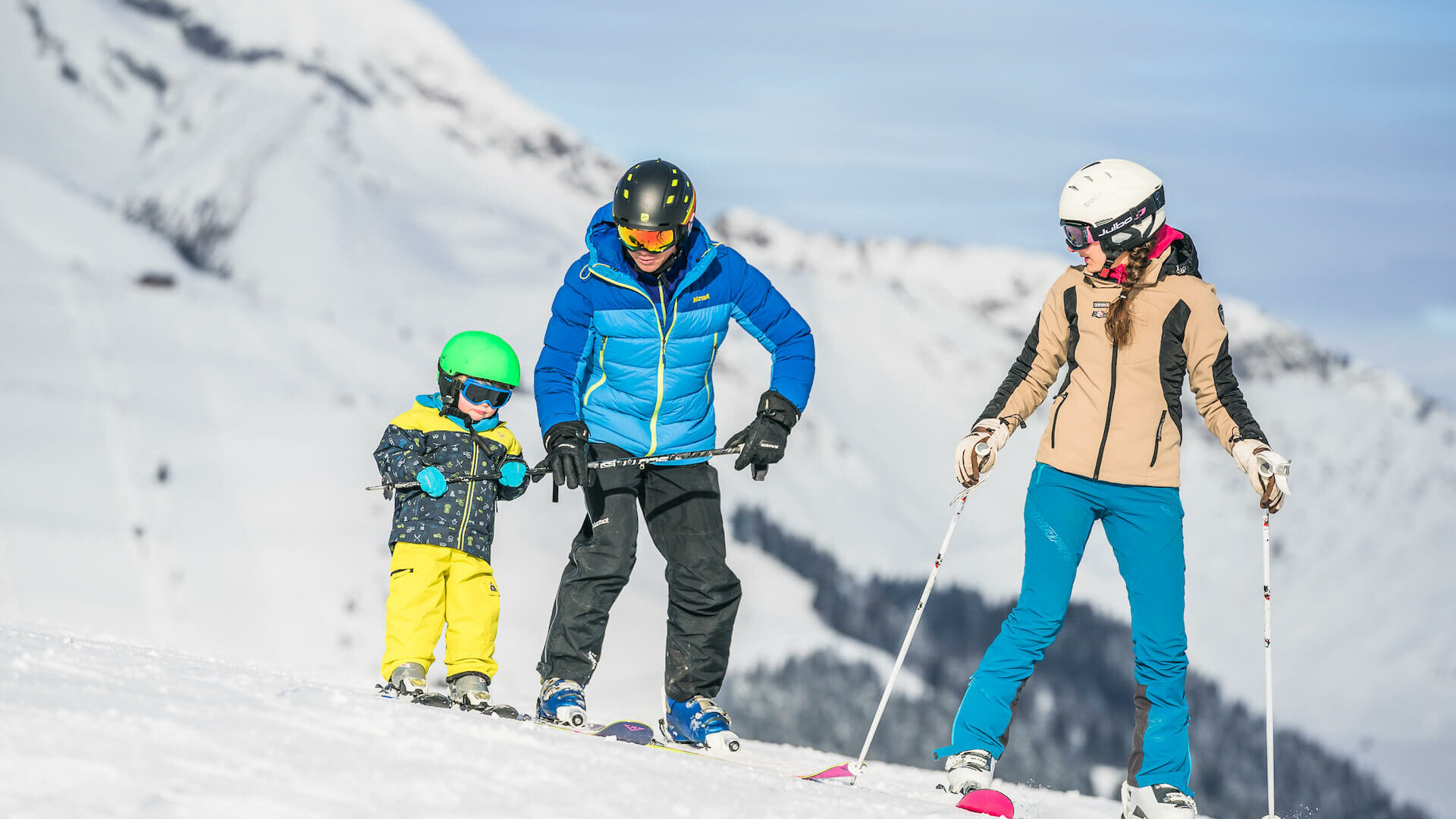 Famille en ski avec parents qui apprennent à leur enfant à skier