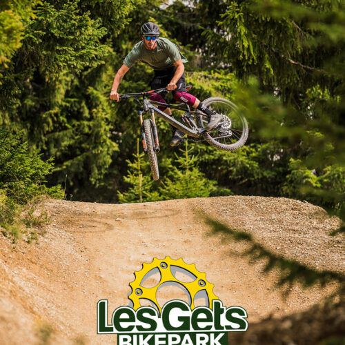 Vététiste faisant une figure avec logo du BikePark des Gets