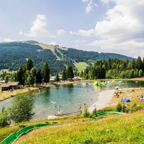 Lac de montagne en été avec jeu gonflable et toboggan