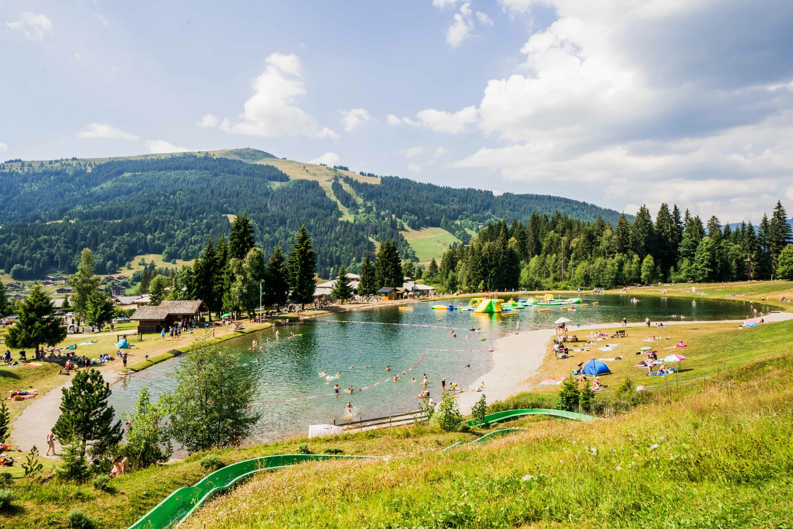 Lac de montagne en été avec jeu gonflable et toboggan