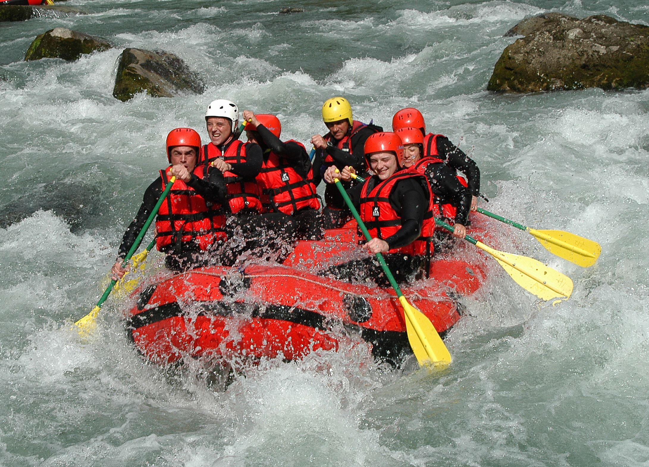 Adultes faisant du rafting dans des rapides