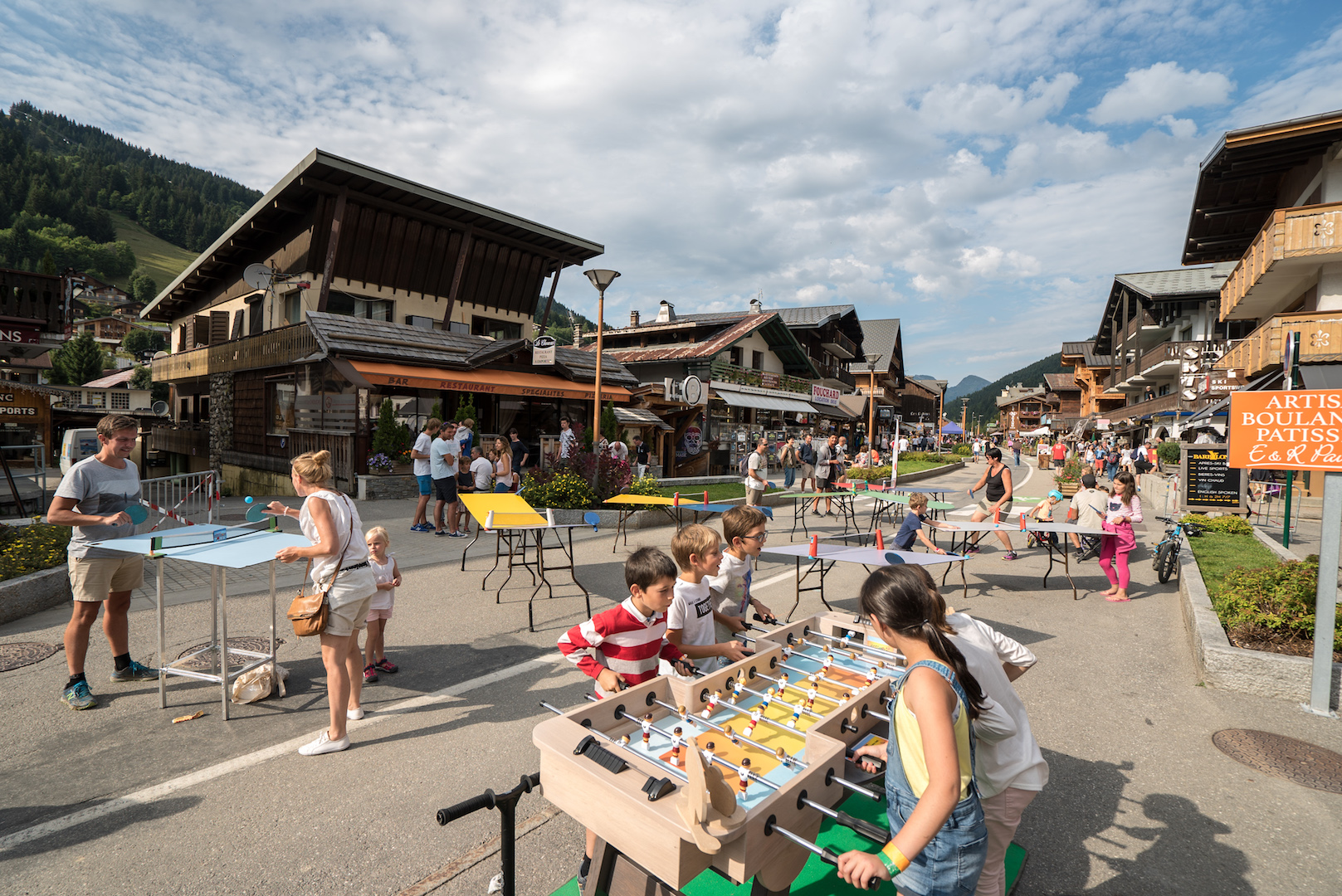 Vacanciers jouant à divers jeux : babyfoot, ping-pong...dans la rue du Centre des Gets