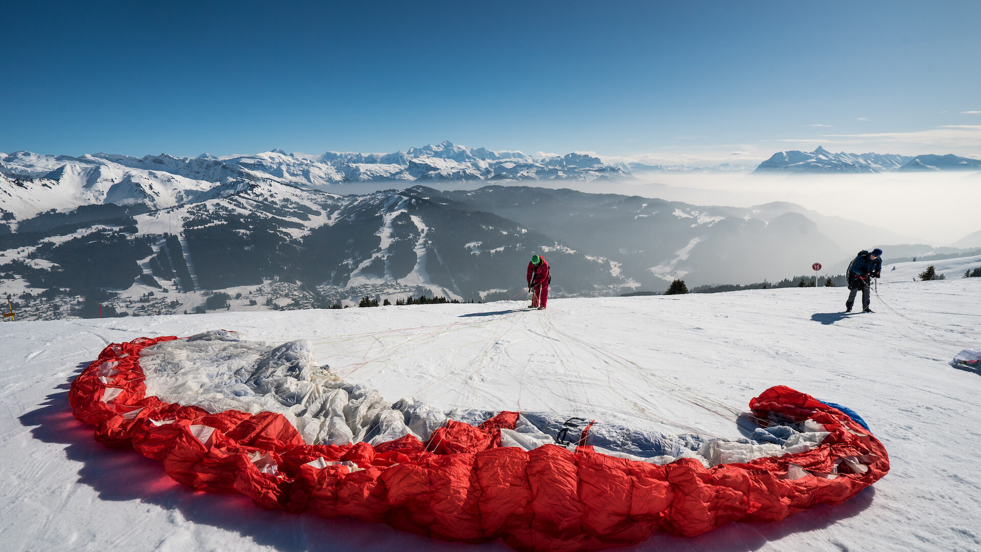 Homme préparant son parapente pour décoller en hiver