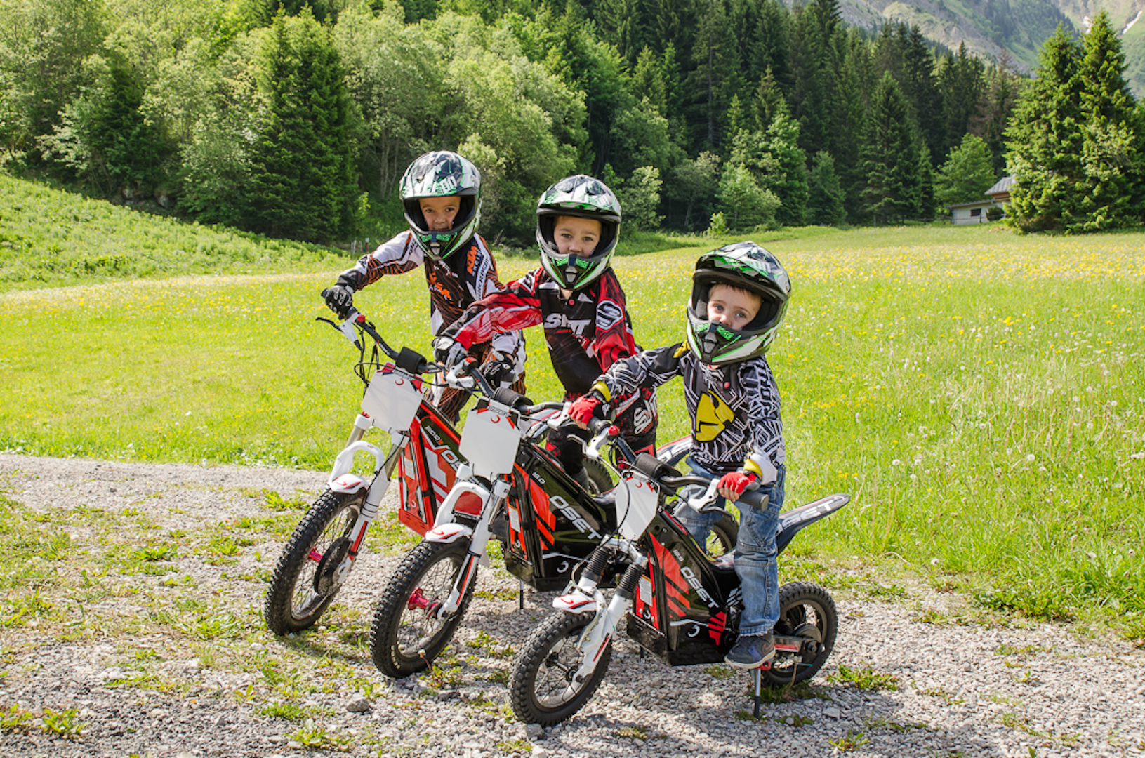 Trois enfants sur des motos électriques en été