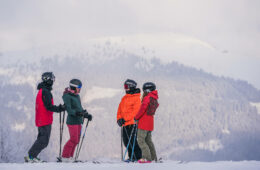 Groupe 4 skieurs avec montagne derrière