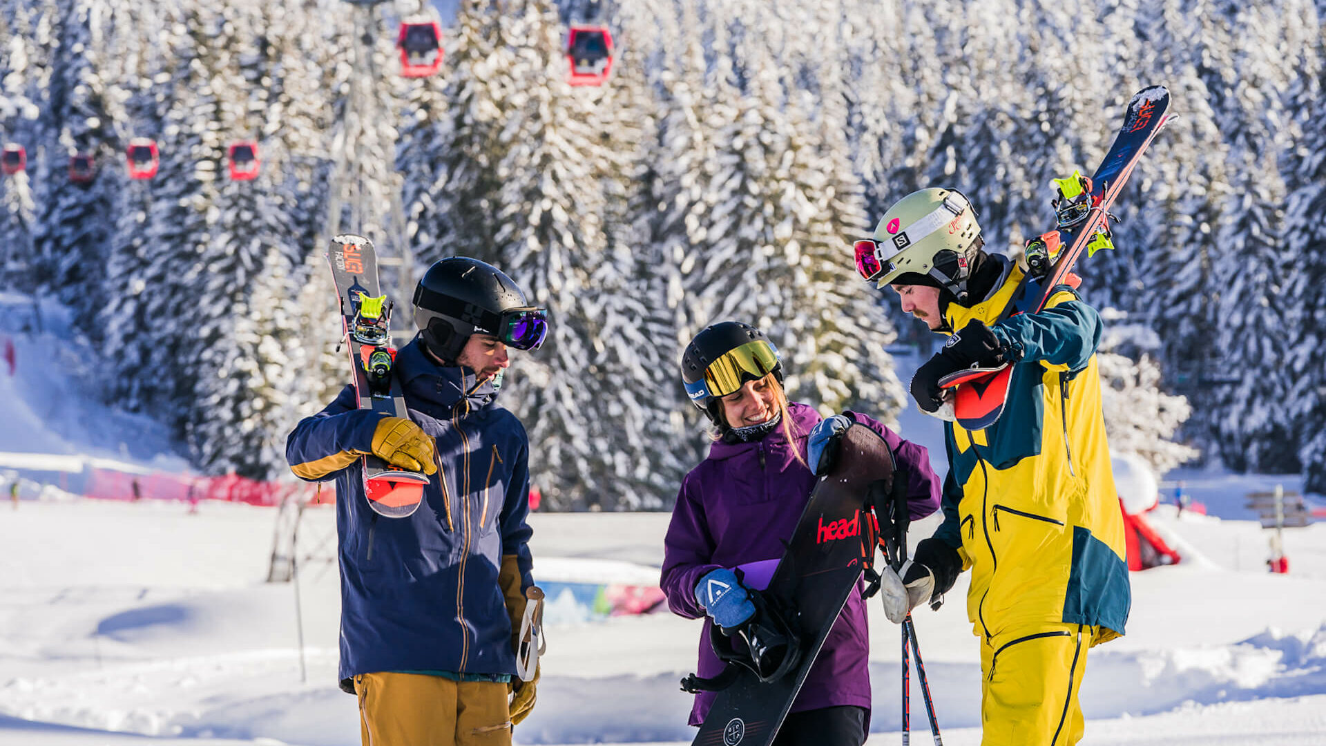 Skieurs et snowboardeuse discutant avec télécabine rouge derrière