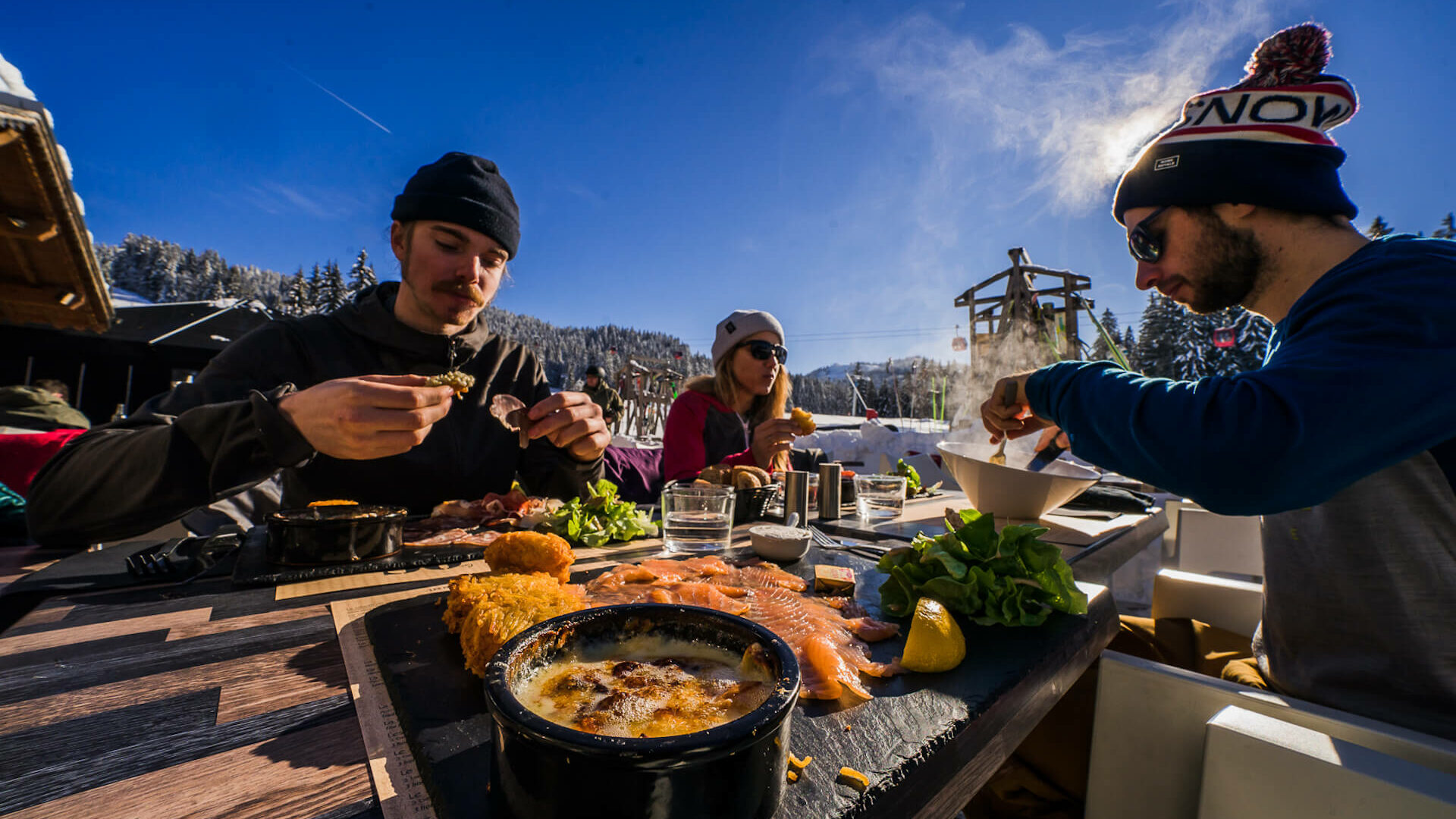 Amis prenant un repas au restaurant en terrasse en hiver