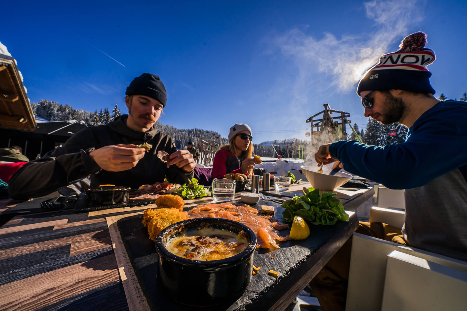 Amis prenant un repas au restaurant en terrasse en hiver