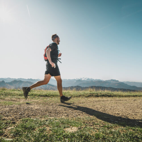 Homme faisant de la course à pied en été en montagne