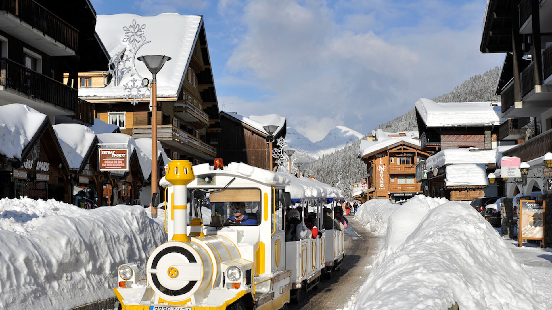 Little train running in a mountain village in winter