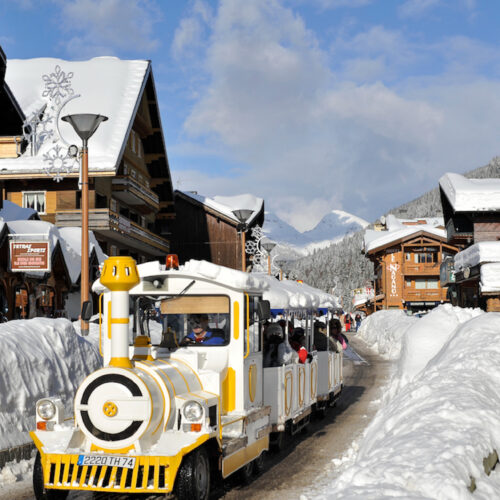 Petit train circulant dans un village de montagne en hiver
