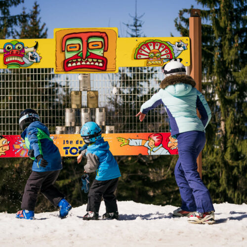 Famille jouant à un jeu sur le thème des indiens en hiver