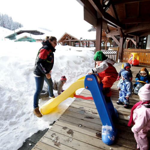 Enfants jouant dans la neige avec toboggan