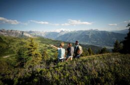 Groupe d'amis randonnant sur la crête de la Rosta et regardant le Mont Blanc