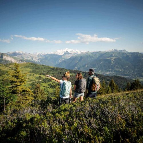 Groupe d'amis randonnant sur la crête de la Rosta et regardant le Mont Blanc